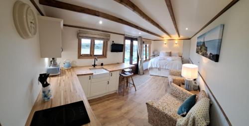 a small room with a kitchen and a bedroom at Ty Beti at Gorlan yr Efail Shepherds Hut with Private Hot Tub in Holyhead