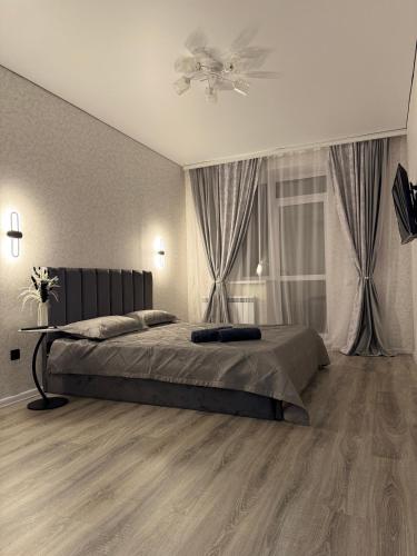 a bedroom with a bed and a ceiling fan at Уютная новая квартира в ЖК Береке 2 рядом с Kostanay Plaza in Kostanay