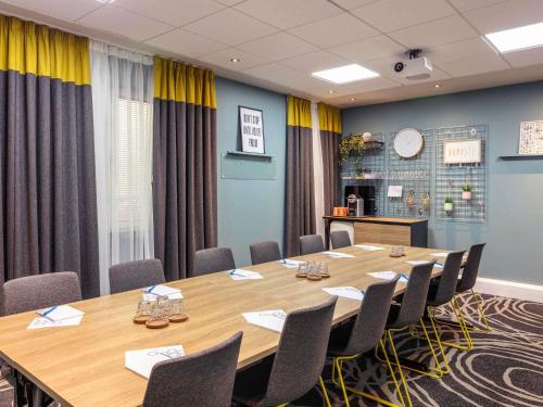 a conference room with a large wooden table and chairs at Novotel Edinburgh Centre in Edinburgh