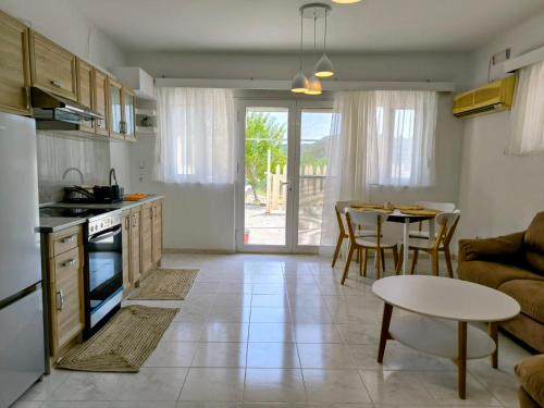 a kitchen and living room with a table and a couch at Costelia Studio in Ialyssos