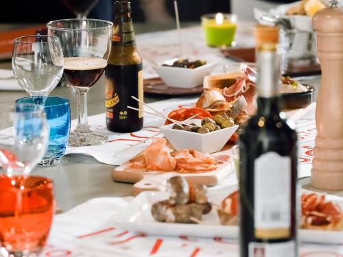 a table topped with plates of food and bottles of wine at Novotel Milton Keynes in Milton Keynes