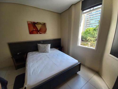 a small bedroom with a bed and a window at Flat - Apartium Palacete Victória in Sao Paulo