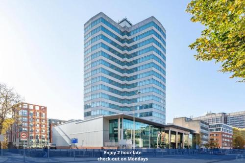 a tall glass building in a city at Holland House Hotel Cardiff By Sunday in Cardiff