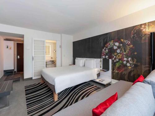 a hotel room with a bed and a couch at Novotel München City in Munich