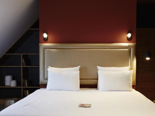 a bed with white sheets and pillows in a room at Novotel München City in Munich