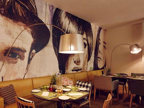 a restaurant with a large painting on the wall at Novotel München City in Munich