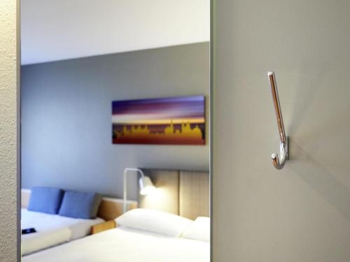 a door to a room with a bed and a mirror at ibis Hotel Würzburg City in Würzburg