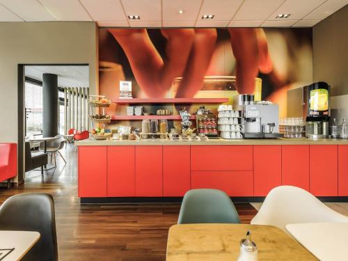 a restaurant with red cabinets and aasteryasteryasteryasteryasteryasteryasteryasteryastery at ibis Hotel Würzburg City in Würzburg