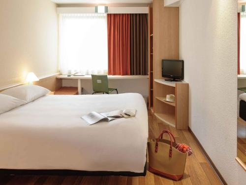 Una cama o camas en una habitación de ibis Stuttgart Centrum