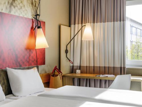 a hotel room with two beds and a window at ibis Hotel München Messe in Feldkirchen