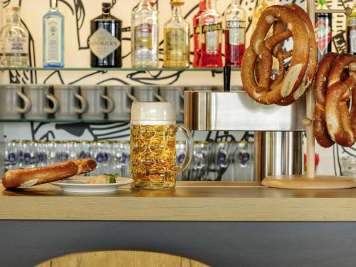 a bar with a glass of beer and pretzels at ibis Hotel München Messe in Feldkirchen