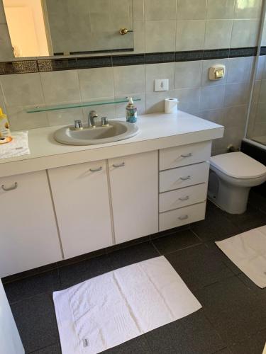 a bathroom with a sink and a toilet and a mirror at Pousada Reserva Gran Descanso in Embu