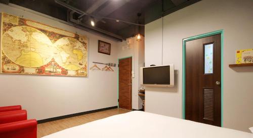 a room with a bed and a tv on a wall at DongNing Atlas Hotel in Tainan