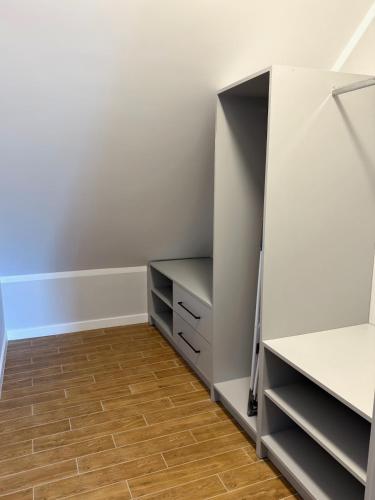 a closet with white cabinets and a wooden floor at Dom w centrum Tucholi in Tuchola