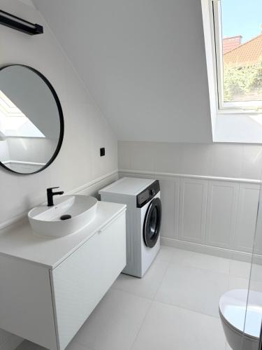 a white bathroom with a washing machine and a sink at Dom w centrum Tucholi in Tuchola