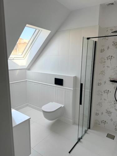 a white bathroom with a toilet and a window at Dom w centrum Tucholi in Tuchola