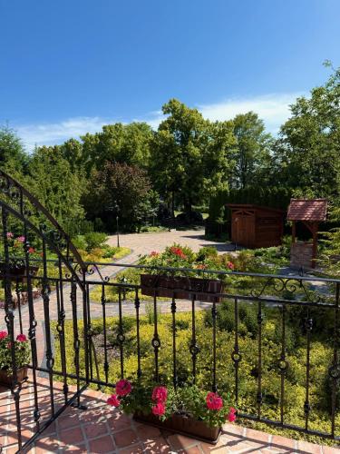 a wrought iron fence with flowers in a garden at Dom w centrum Tucholi in Tuchola