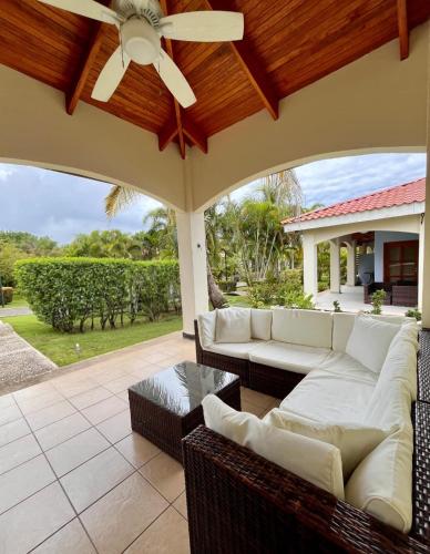 a patio with white couches and a ceiling fan at Sueño al Mar Residence & Hotel in Potrero