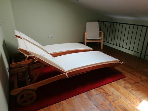 a room with two beds and a chair on a floor at Relax cottage in Querce