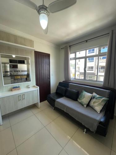 a living room with a couch and a large window at Residencial Nicole in Florianópolis