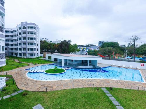 une grande piscine dans un parc avec un bâtiment dans l'établissement Luxury Beachfront apartment at Baobab Waves, à Mombasa