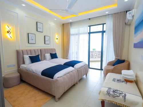- une grande chambre avec un grand lit et une chaise dans l'établissement Luxury Beachfront apartment at Baobab Waves, à Mombasa
