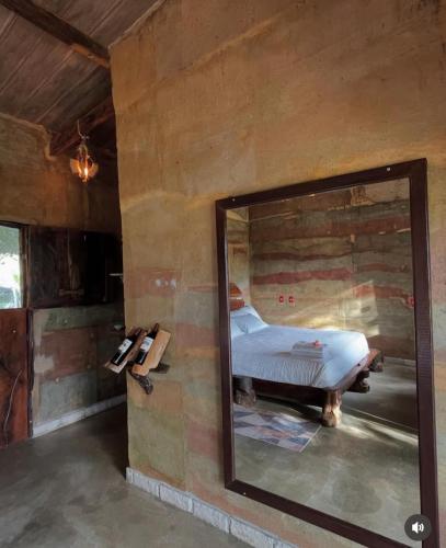 a mirror in a room with a bed in it at Pousada Toca da Raposa in Cavalcante