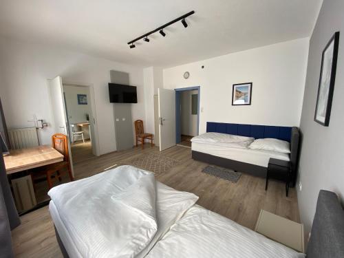 a bedroom with two beds and a living room with a desk at Apartment Q im Zentrum von Königsbronn in Königsbronn