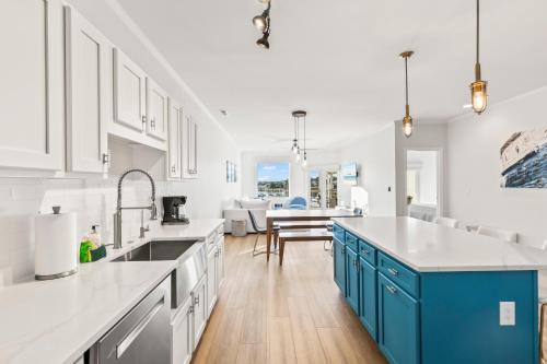 a kitchen with white walls and blue cabinets at New Listing! Moorings 510 - Yacht View Serenity! in Isle of Palms