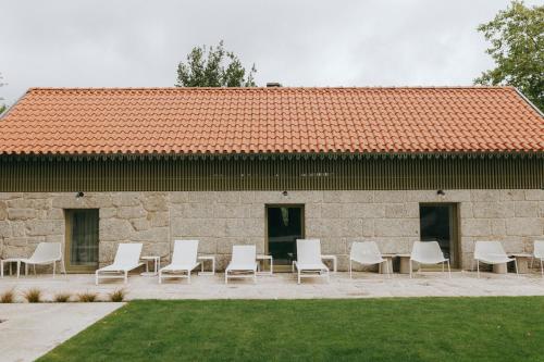 a group of chairs and tables in front of a building at Casa da Fonte de Cima in Celorico de Basto