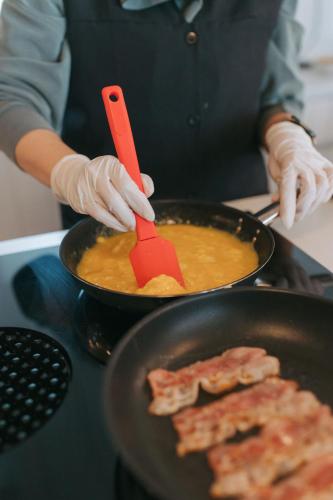 a person is cooking food in a pan with bacon at Casa da Fonte de Cima in Celorico de Basto
