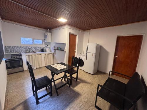 Una cocina con mesa y sillas y un refrigerador. en Dulces sueños, en Presidencia Roque Sáenz Peña