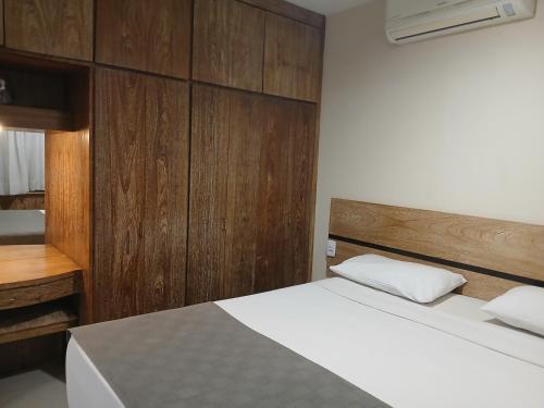 a bedroom with a bed and a wooden wall at Landmark Residence - OFICIAL in Sao Paulo