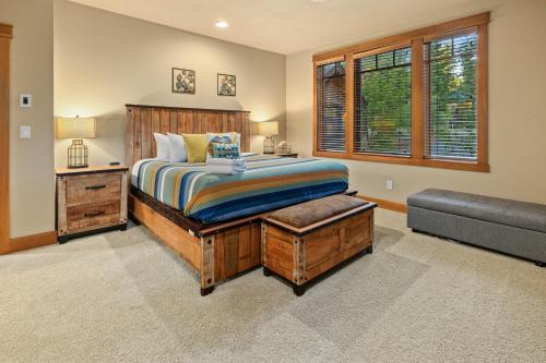 a bedroom with a bed with a bench and a window at Whispering Pines Escape in Suncadia- Hot Tub, BBQ, Firepit, Fully Equipped Kitchen, Smart TVs, Hi-speed Wi-Fi in Roslyn