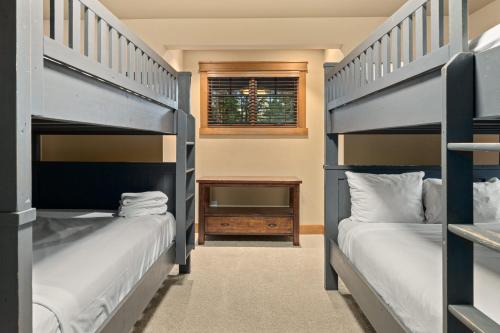 two bunk beds in a room with a window at Whispering Pines Escape in Suncadia- Hot Tub, BBQ, Firepit, Fully Equipped Kitchen, Smart TVs, Hi-speed Wi-Fi in Roslyn
