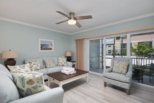 un salon avec un canapé et un ventilateur de plafond dans l'établissement Villa Sanibel 2A - Exclusive Villa Sanibel Retreat Steps to Beach, à Ybel