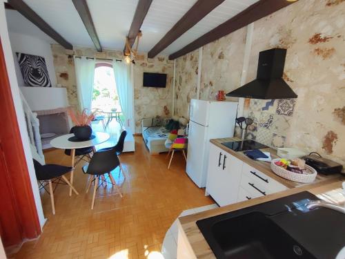 a kitchen with white appliances and a table with chairs at Spasmata Village Special Maizonette only adults in Minia