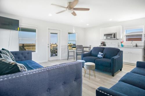 a living room with two blue couches and a kitchen at Charming home with fantastic view in Bolivar Peninsula