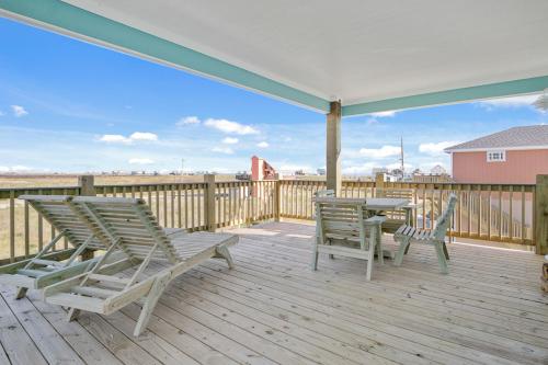 a patio with two chairs and a table on a deck at Charming home with fantastic view in Bolivar Peninsula