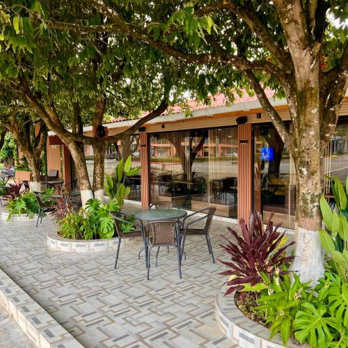 a patio with a table and chairs in front of a building at Hostería Horizontes in Caucasia