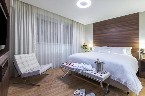 una camera da letto con un grande letto bianco e una sedia di Hotel Juan William em Brasilândia a Panorama