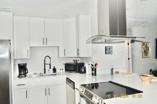 a white kitchen with white cabinets and a sink at Fully Furnished Home in St Cloud in Saint Cloud