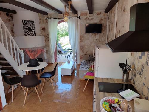 a kitchen and living room with a table and chairs at Spasmata Village Special Maizonette only adults in Minia