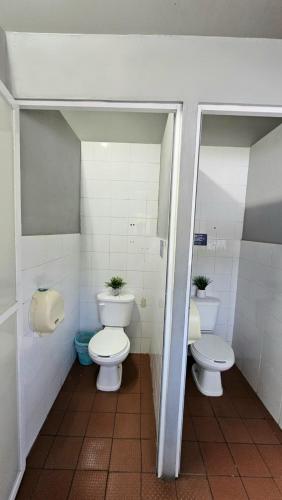 a bathroom with two toilets and two sinks in it at Hostel Auikyani in Cozumel