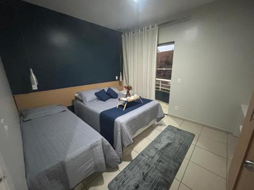 sypialnia z dwoma łóżkami i stołem w obiekcie Flat Apart hotel Village - ao lado do Aldeia das Aguas w mieście Barra do Piraí