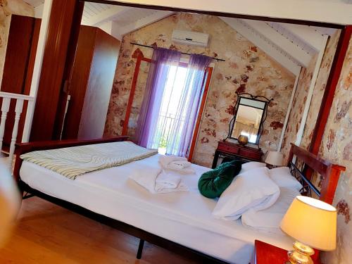 a bedroom with a large white bed with a mirror at Spasmata Village Special Maizonette only adults in Minia