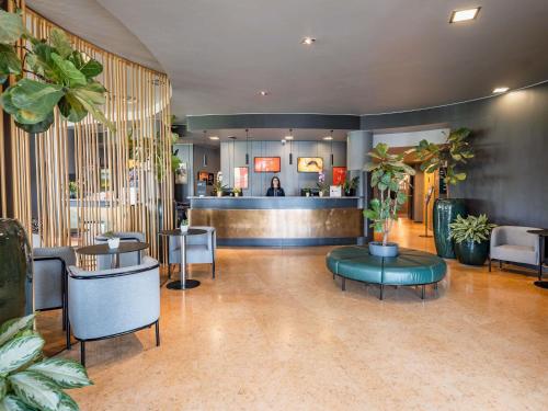 a lobby with tables and chairs and a bar at Hotel Ibis Firenze Prato Est in Campi Bisenzio