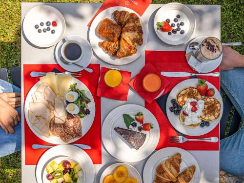 a table with plates of breakfast food on it at Hotel Ibis Firenze Prato Est in Campi Bisenzio