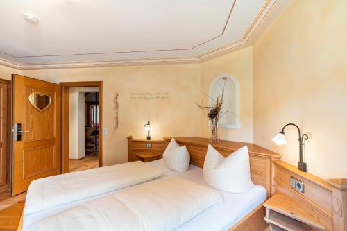 a bedroom with a large white bed with white pillows at Wein- und Klimahotel Bergfriedel in Bühlertal