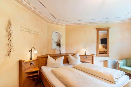 a bedroom with a large bed with white pillows at Wein- und Klimahotel Bergfriedel in Bühlertal